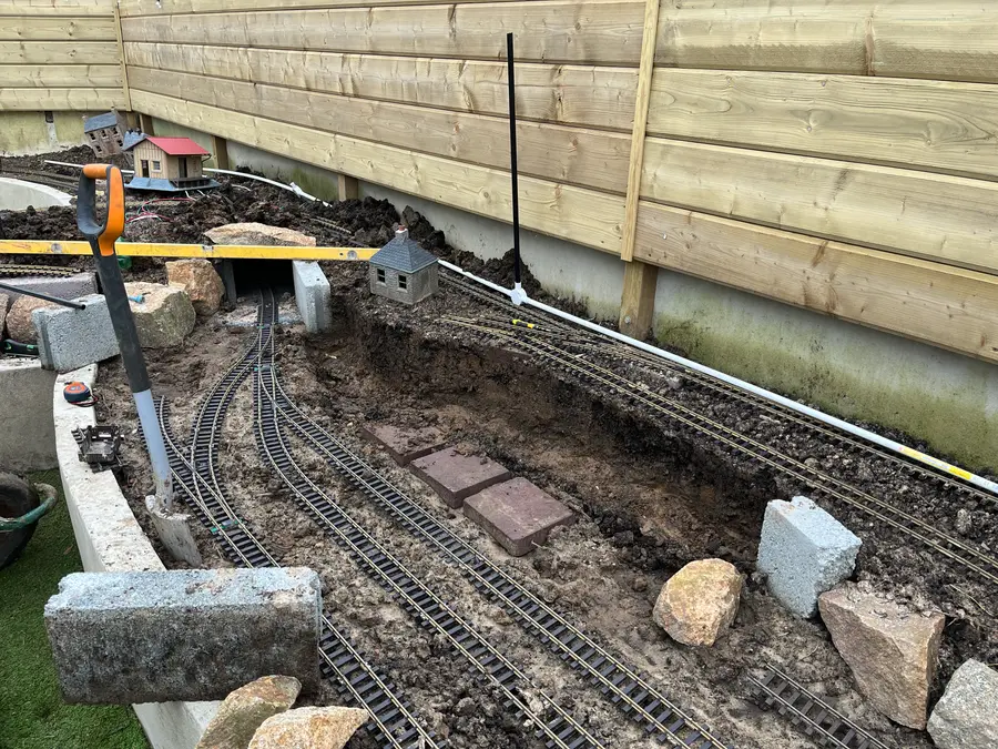 Track being laid amid freshly dug earth and Jersey granite, 2021