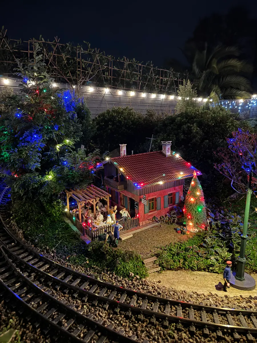 A festively lit miniature scene tucked into the railway for the Christmas scavenger hunt